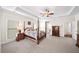 Well-lit main bedroom featuring tray ceilings, a plush bed, and charming decor at 930 Crestview Dr, Johns Creek, GA 30024