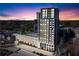 Exterior view of the residential tower with parking and green space and amazing sunset at 2425 Peachtree Ne Rd # 1211, Atlanta, GA 30305