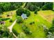 Lush green acreage featuring a home nestled among mature trees, cleared lawn, and gravel drive at 3545 Liberty Rd, Villa Rica, GA 30180