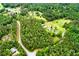 Aerial view of a lush landscape featuring winding roads, a charming home, and verdant trees at 3545 Liberty Rd, Villa Rica, GA 30180