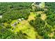 An aerial view of a charming home nestled on lush green land featuring outbuildings and a winding driveway at 3545 Liberty Rd, Villa Rica, GA 30180