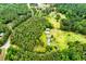An aerial view of a property with a winding driveway, lush greenery, and a home with multiple outbuildings at 3545 Liberty Rd, Villa Rica, GA 30180