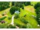 Green acreage featuring a home nestled among mature trees, expansive lawn, and gravel drive at 3545 Liberty Rd, Villa Rica, GA 30180