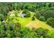 Verdant property featuring a home nestled among mature trees, expansive lawn, and agricultural fields at 3545 Liberty Rd, Villa Rica, GA 30180