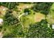 An aerial view of a house nestled among dense, lush trees with open grassy spaces at 3545 Liberty Rd, Villa Rica, GA 30180