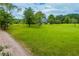 Lush, sprawling front lawn with mature trees, leading to a charming home on a bright day at 3545 Liberty Rd, Villa Rica, GA 30180