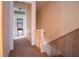 Hallway with stairs, wooden railings, and view into adjacent room with decor at 3545 Liberty Rd, Villa Rica, GA 30180