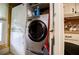 Washer and dryer hookups, utility sink, and storage shelves in a compact laundry room at 3545 Liberty Rd, Villa Rica, GA 30180