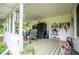 Inviting covered porch with outdoor seating, dining table, and a full-sized refrigerator for extra storage at 3545 Liberty Rd, Villa Rica, GA 30180