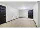 Finished basement with two black doors, carpet, and neutral paint at 8355 Ainsworth Dr, Cumming, GA 30041