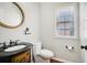 Charming half bath with ornate vanity, rope-framed mirror, and stylish fixtures at 8355 Ainsworth Dr, Cumming, GA 30041