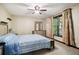 Well-lit bedroom with a ceiling fan, large window, and carpeted floors at 8355 Ainsworth Dr, Cumming, GA 30041
