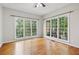 Sun-filled bedroom featuring hardwood floors and large windows with a view of lush greenery at 8355 Ainsworth Dr, Cumming, GA 30041