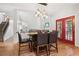 Dining area offers access to the outdoors with an elegant light fixture and hardwood floors at 8355 Ainsworth Dr, Cumming, GA 30041