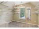 Spacious walk-in closet with multiple shelves and a window for natural light at 8355 Ainsworth Dr, Cumming, GA 30041
