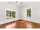 Bright bedroom with hardwood floors and dual windows overlooking the yard at 159 Forest Ave, Social Circle, GA 30025
