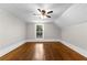 Empty upstairs bedroom with hardwood floors, ceiling fan, and window at 159 Forest Ave, Social Circle, GA 30025