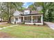 Beautiful home with a welcoming front porch, manicured lawn, and well-maintained landscaping at 159 Forest Ave, Social Circle, GA 30025