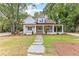 Inviting home featuring a spacious front porch, stone pathway, and beautifully landscaped yard at 159 Forest Ave, Social Circle, GA 30025