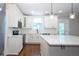 Bright kitchen featuring white cabinets, quartz countertops, stainless appliances and hardwood floors at 159 Forest Ave, Social Circle, GA 30025