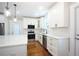 Bright kitchen with white cabinets, quartz countertops, and stainless steel appliances and hardwood floors at 159 Forest Ave, Social Circle, GA 30025