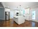 Bright, open kitchen with hardwood floors, white cabinets, stainless steel appliances and center island at 159 Forest Ave, Social Circle, GA 30025