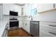 Bright kitchen with white cabinets, quartz countertops, stainless appliances and hardwood floors at 159 Forest Ave, Social Circle, GA 30025