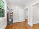 Utility room with hardwood floors, a water heater, and a window offering natural light at 159 Forest Ave, Social Circle, GA 30025