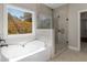 Modern bathroom featuring a soaking tub next to a glass enclosed shower and an exterior view at 1847 Davis Mill Rd, Dallas, GA 30157