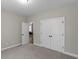 A bedroom featuring soft gray walls, plush carpeting, and a double door closet at 1847 Davis Mill Rd, Dallas, GA 30157