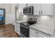 Kitchen includes a stainless steel stove and microwave, white cabinets, and granite countertops at 1847 Davis Mill Rd, Dallas, GA 30157