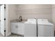 Well-lit laundry room with granite countertops, black hardware, and white front loading washer and dryer at 1847 Davis Mill Rd, Dallas, GA 30157
