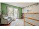 Unique bedroom with green accent walls, hardwood floors and an oversized comfortable chair at 2101 Kinridge Rd, Marietta, GA 30062