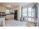 Well-lit kitchen with white cabinets, granite countertops, stainless steel appliances, and a glass table at 2101 Kinridge Rd, Marietta, GA 30062