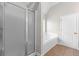 Bathroom features a glass enclosed shower, a bathtub with white tile, and tile flooring at 2443 High Meadows Ct, Conyers, GA 30094