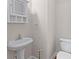 Cozy half-bathroom features a classic pedestal sink and toilet, offering convenience for guests at 2443 High Meadows Ct, Conyers, GA 30094