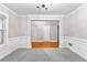 Bright, open living room with wainscoting, neutral walls, and plush gray carpet, perfect for modern living at 2443 High Meadows Ct, Conyers, GA 30094
