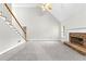 Bright living room featuring a stone fireplace, staircase, and vaulted ceiling, perfect for relaxation and entertainment at 2443 High Meadows Ct, Conyers, GA 30094