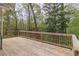 Spacious back deck with wood railings and a serene view at 275 Sageglen Rd, Lawrenceville, GA 30044
