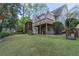 Backyard featuring a grassy lawn, wooden deck, screened-in porch, and picturesque landscaping at 275 Sageglen Rd, Lawrenceville, GA 30044