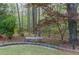 Backyard featuring a stone bench along a stone walkway, surrounded by mature trees and foliage at 275 Sageglen Rd, Lawrenceville, GA 30044
