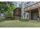 Backyard featuring a grassy lawn, mature trees, and an elevated screened-in porch at 275 Sageglen Rd, Lawrenceville, GA 30044
