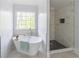 Bright bathroom featuring a soaking tub next to a window and a separate tiled shower at 275 Sageglen Rd, Lawrenceville, GA 30044