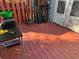 View of the deck with red painted floor, utility equipment, and access door at 6438 Wedgeview Dr, Tucker, GA 30084