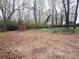 Spacious wooded backyard with a red storage shed providing ample outdoor space at 110 N River Rd, Mcdonough, GA 30252