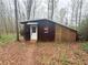 Exterior of a small cabin featuring wood siding, a lattice wall, and a simple door in a natural setting at 110 N River Rd, Mcdonough, GA 30252