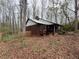 Charming single-story home with a covered porch and brown wood siding, nestled among trees with a ground cover yard at 110 N River Rd, Mcdonough, GA 30252