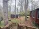 Exterior view of cabin and outbuilding, framed by trees, with access via weathered wooden steps at 110 N River Rd, Mcdonough, GA 30252
