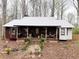 Charming single-story home with a rustic porch, metal roof, and stone foundation at 110 N River Rd, Mcdonough, GA 30252