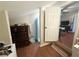 Hallway view with hardwood floors, leading to a bathroom and living area with an adjacent laundry area at 110 N River Rd, Mcdonough, GA 30252